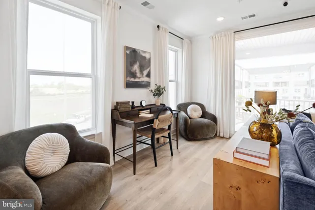 a living room with furniture ceiling fan and a window