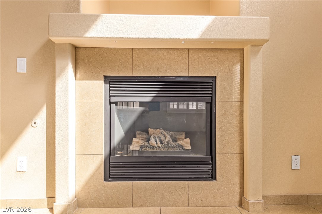 1477 Rancho Ridge Drive Henderson, NV 89012 - Photo 12 of 46 A refined tile-surrounded fireplace provides warmth and a focal point to the living space.