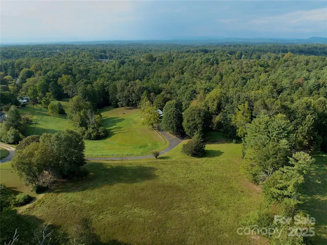 a view of a big yard with large trees