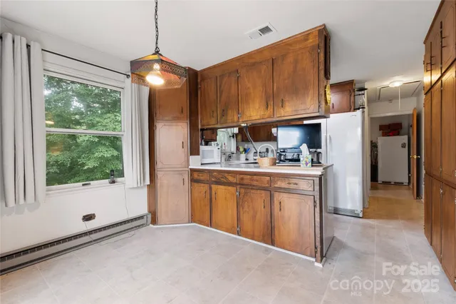 a kitchen with stainless steel appliances granite countertop a refrigerator a sink dishwasher and wooden cabinets with wooden floor