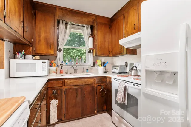 a kitchen with stainless steel appliances granite countertop a sink a stove and a refrigerator