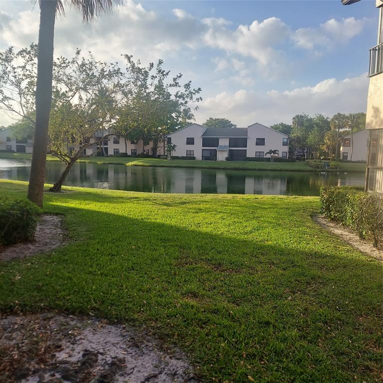 3420 Northwest 47th Avenue, Unit 3143 Pompano Beach, FL 33063 - Photo 7 of 14 a view of a lake with a house in the background