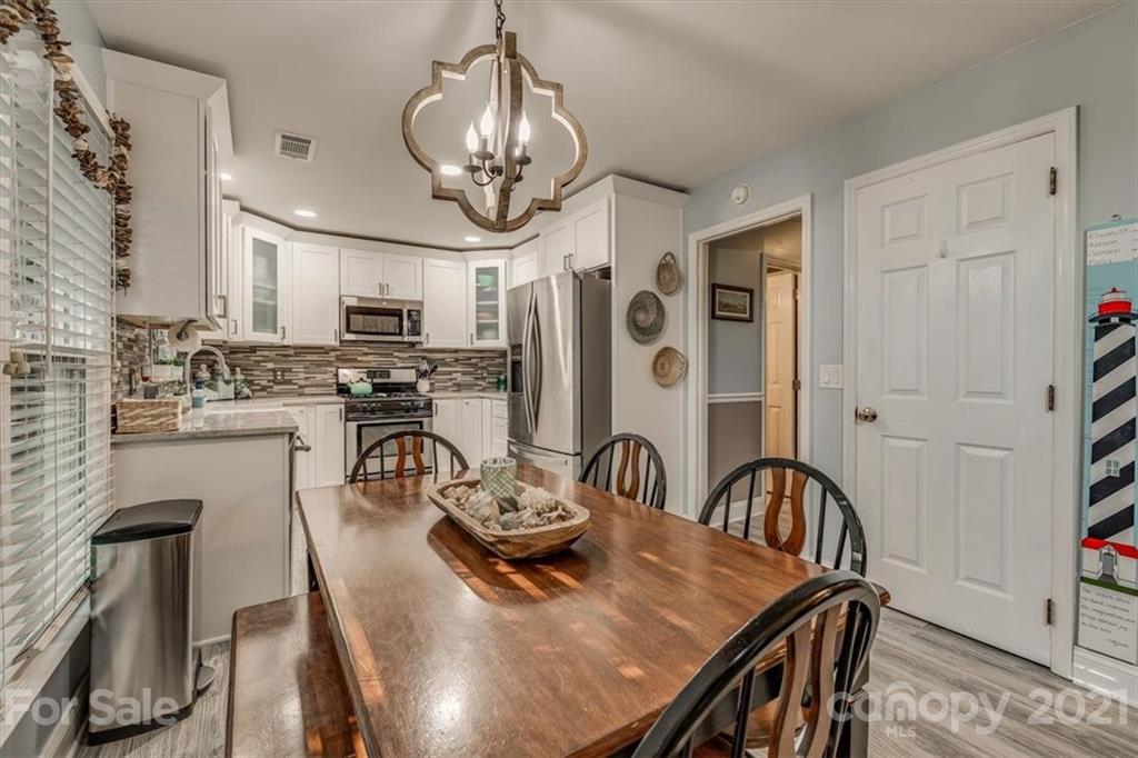 2129 Manawa Lane Tega Cay, SC 29708 - Photo 15 of 42 a view of a dining room with furniture a chandelier and wooden floor