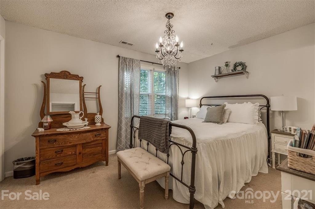 2129 Manawa Lane Tega Cay, SC 29708 - Photo 9 of 42 a bedroom with a bed and a chandelier