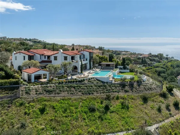 an aerial view of residential house with outdoor space and trees all around