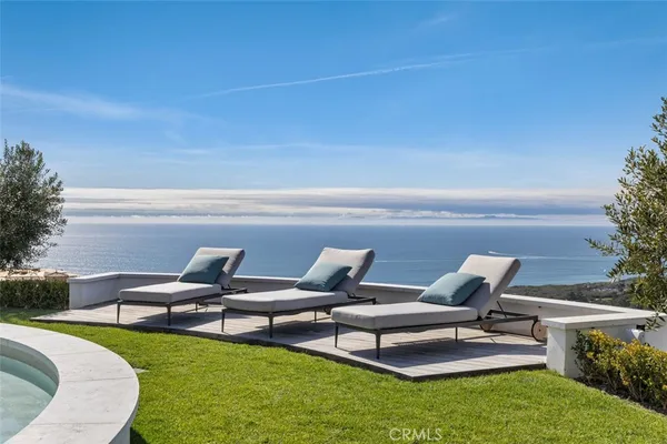 a couple of blue chairs sitting in a yard with swimming pool