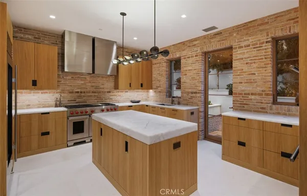 a kitchen with stainless steel appliances granite countertop a sink a stove and a refrigerator