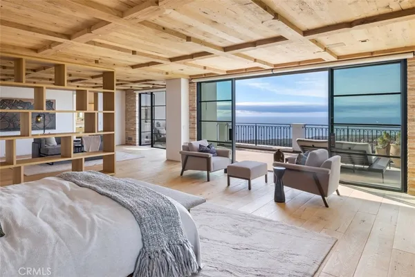 a spacious bedroom with a bed a couch and large window