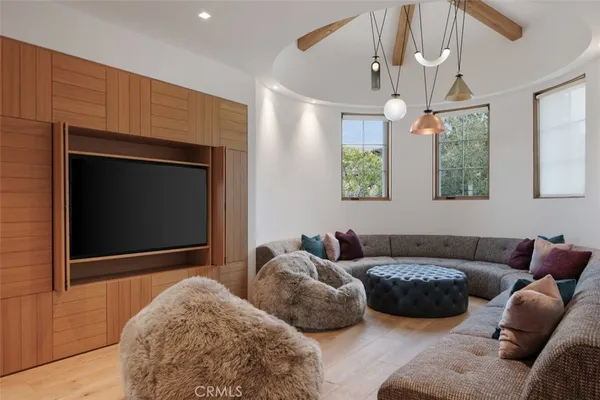 a living room with couches a fireplace and a chandelier