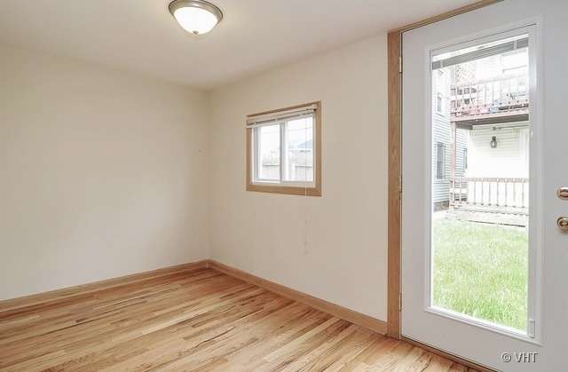 4205 North Bernard Street, Unit R Chicago, IL 60618 - Photo 2 of 12 a view of an empty room with wooden floor and a window