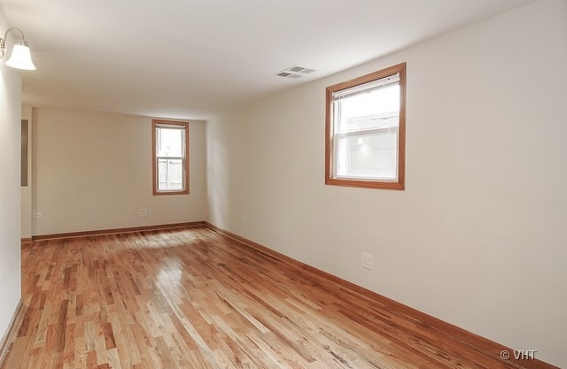 4205 North Bernard Street, Unit R Chicago, IL 60618 - Photo 3 of 12 a view of an empty room with wooden floor and a window