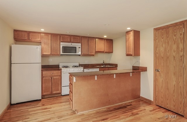 4205 North Bernard Street, Unit R Chicago, IL 60618 - Photo 4 of 12 a kitchen with stainless steel appliances granite countertop a refrigerator a stove a sink and a microwave