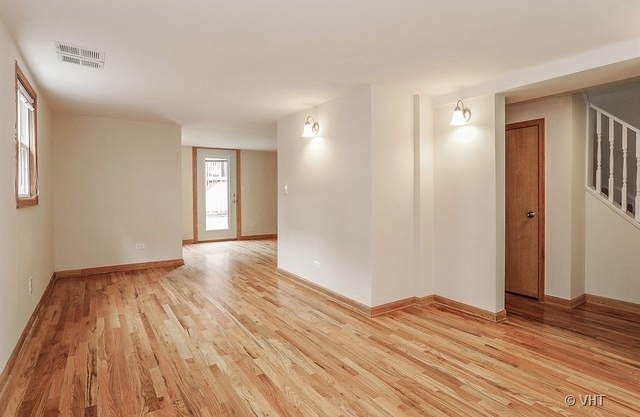 4205 North Bernard Street, Unit R Chicago, IL 60618 - Photo 5 of 12 a view of empty room with wooden floor and fan