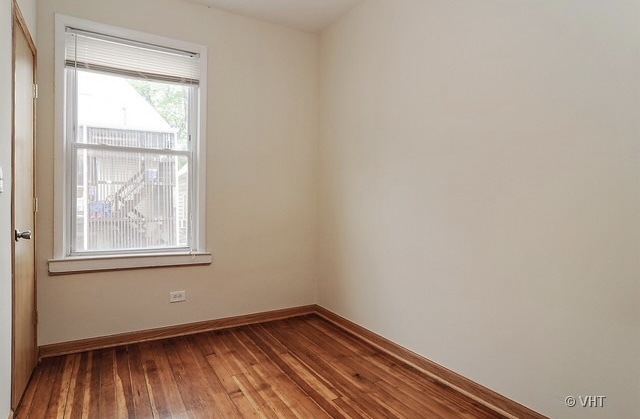 4205 North Bernard Street, Unit R Chicago, IL 60618 - Photo 7 of 12 an empty room with wooden floor and windows