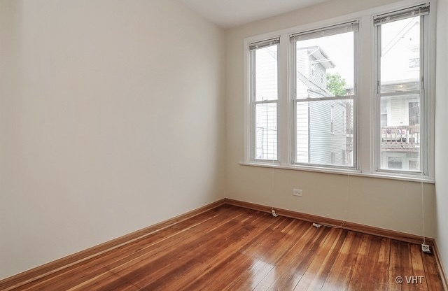 4205 North Bernard Street, Unit R Chicago, IL 60618 - Photo 8 of 12 a view of empty room with wooden floor and fan