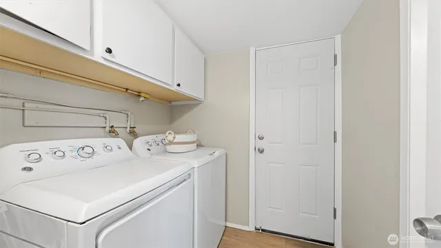 a kitchen with a dining table chairs and white cabinets