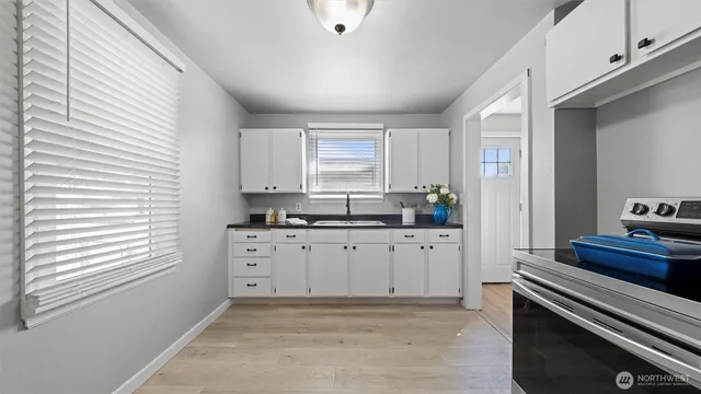 a kitchen with granite countertop white cabinets and white appliances