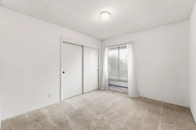 an empty room with windows and closet