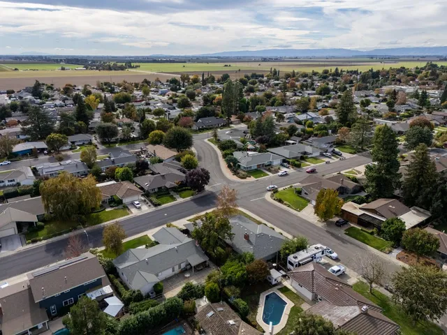 an aerial view of a house with a yard and large tree