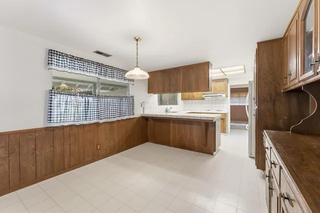 a kitchen with kitchen island cabinets a sink and a stove