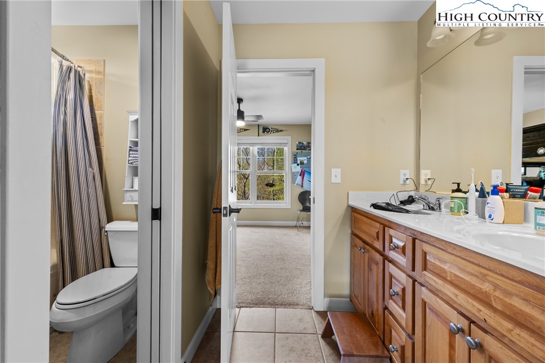 162 Pinecrest Court Boone, NC 28607 - Photo 36 of 50 a bathroom with a granite countertop sink a toilet a mirror and shower