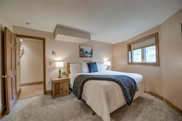 a spacious bedroom with a bed and a lamp