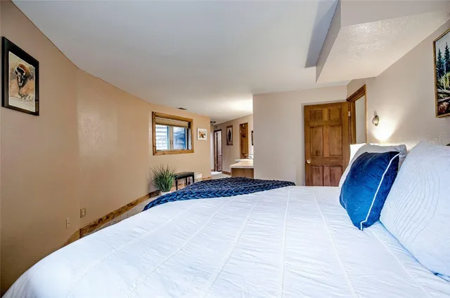 a bedroom with a large bed wooden floor and window