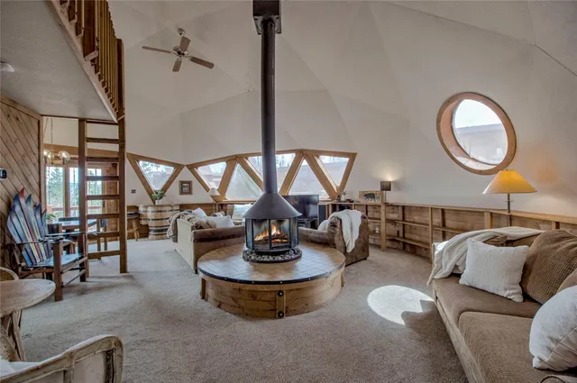 a living room with furniture a chandelier and a large window