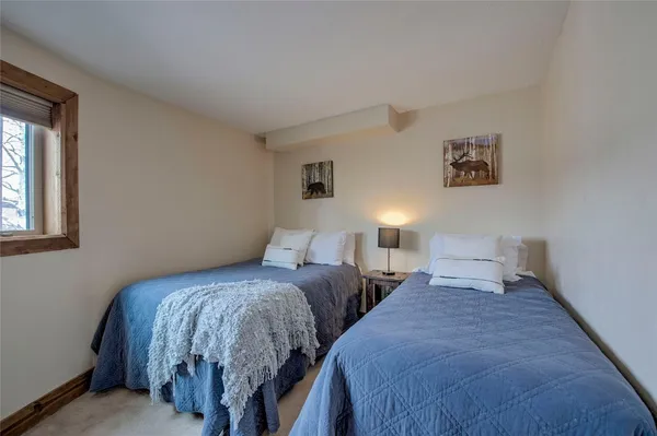 a bedroom with two beds and a lamp