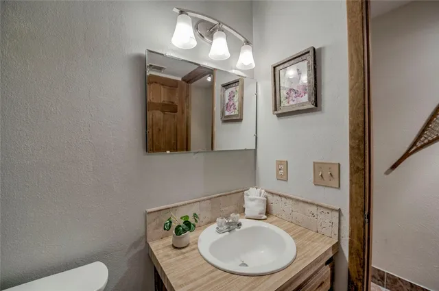 a bathroom with a toilet a sink and mirror