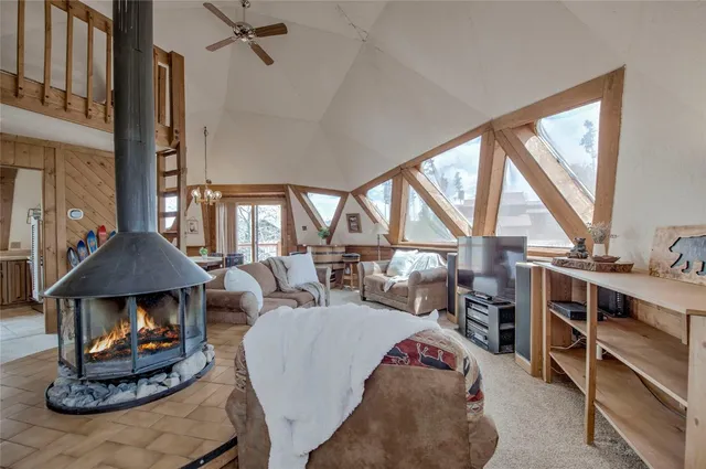 a living room with furniture a fireplace and large windows