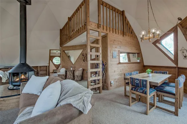a living room with furniture a fireplace and a chandelier