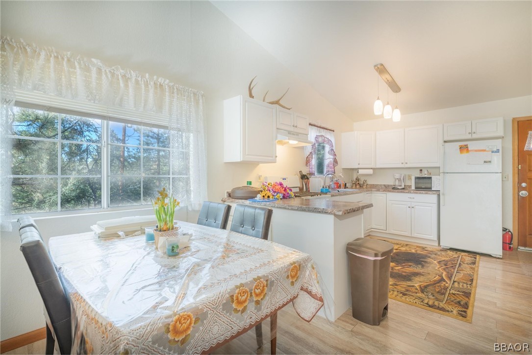 124 Riverside Avenue Sugarloaf, CA 92386 - Photo 8 of 22 a kitchen with a table chairs and white cabinets
