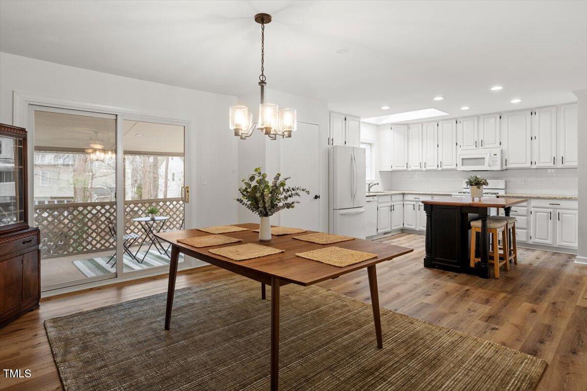 1203 Brookgreen Drive Cary, NC 27511 - Photo 10 of 46 a room with stainless steel appliances kitchen island granite countertop a dining table chairs and white cabinets