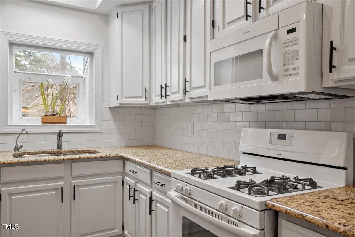 1203 Brookgreen Drive Cary, NC 27511 - Photo 13 of 46 a kitchen with granite countertop cabinets and a stove top oven