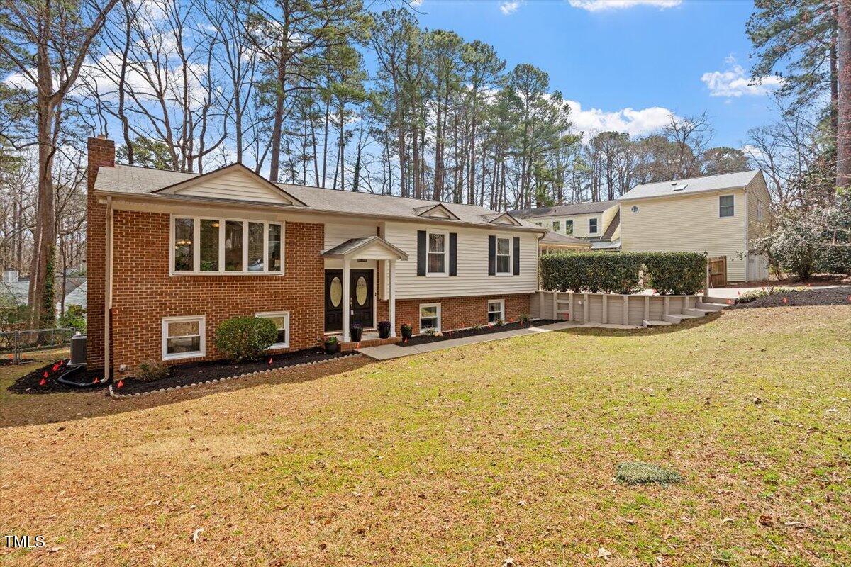 1203 Brookgreen Drive Cary, NC 27511 - Photo 2 of 46 a front view of a house with yard and trees in the background