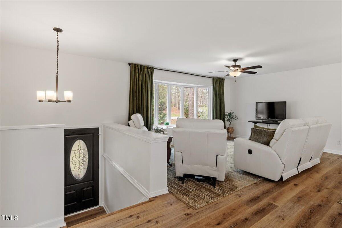 1203 Brookgreen Drive Cary, NC 27511 - Photo 7 of 46 a living room with furniture a chandelier and a window