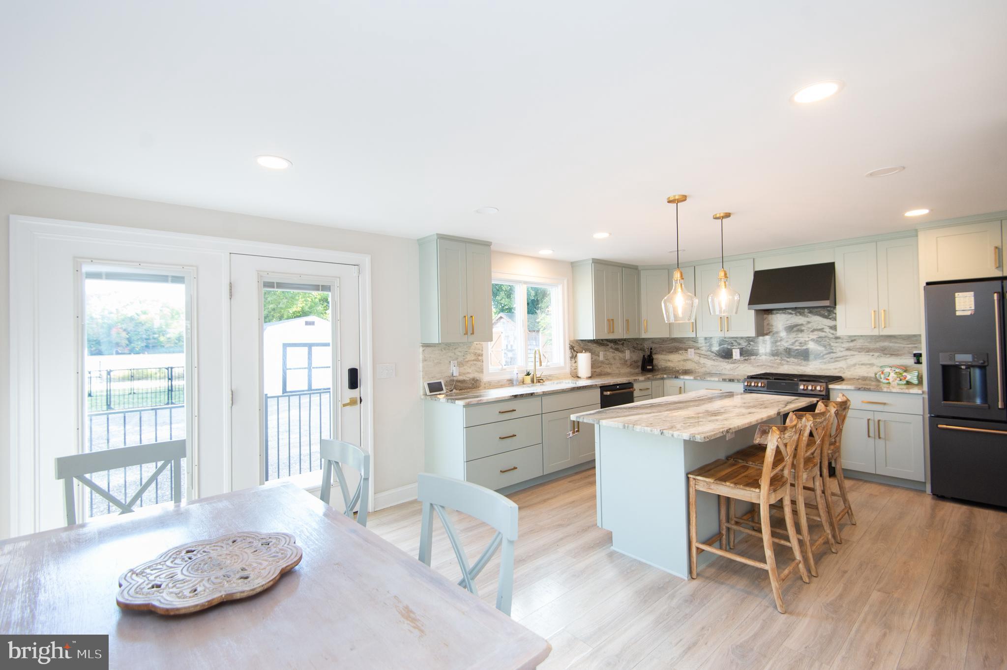 110 Second Street Secretary, MD 21664 - Photo 12 of 36 a kitchen with a stove a sink dishwasher a dining table and chairs with wooden floor