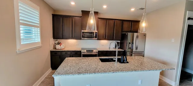a kitchen with kitchen island a counter space and a refrigerator