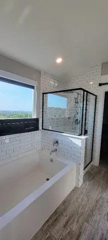 a spacious bathroom with a bathtub and a shower