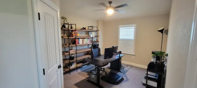 a view of a workspace with furniture and a window