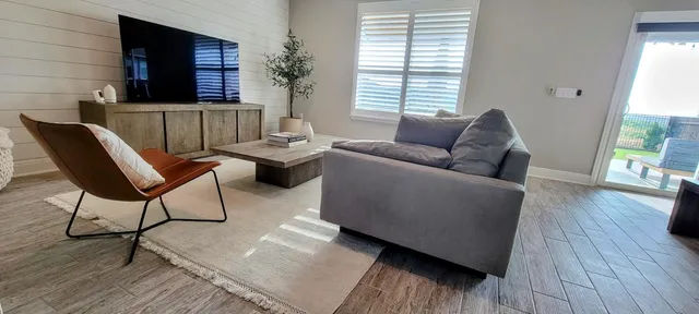 a living room with furniture and wooden floor