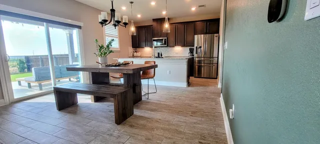 a kitchen with stainless steel appliances granite countertop a stove refrigerator and a view of living room