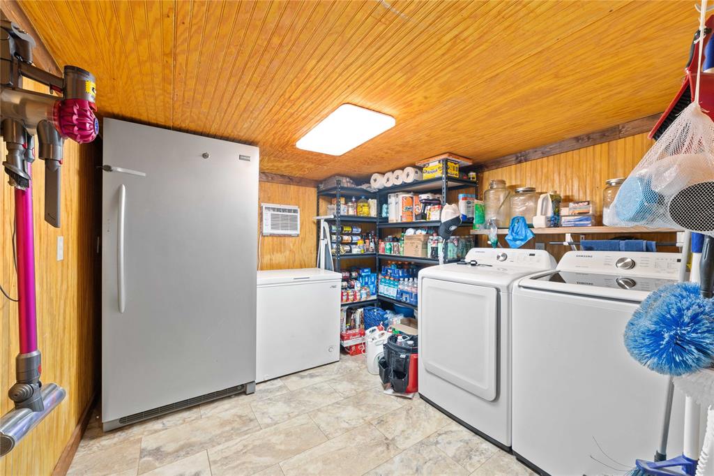 4991 Thunderbird Drive May, TX 76857 - Photo 22 of 34 Laundry area with wood ceiling, wood walls, laundry area, and washing machine and dryer