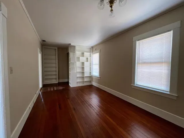 wooden floor in an empty room with a window