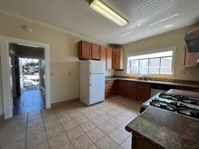 a kitchen with stainless steel appliances granite countertop a stove a sink and a refrigerator