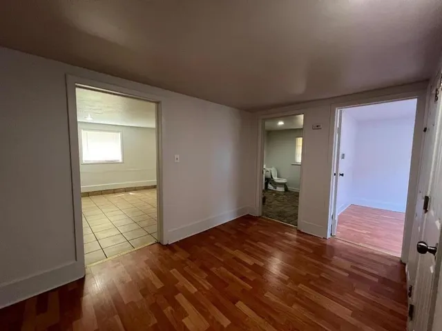 a view of empty room with wooden floor