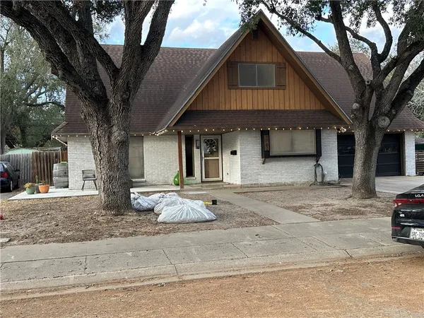 a front view of a house with cars parked
