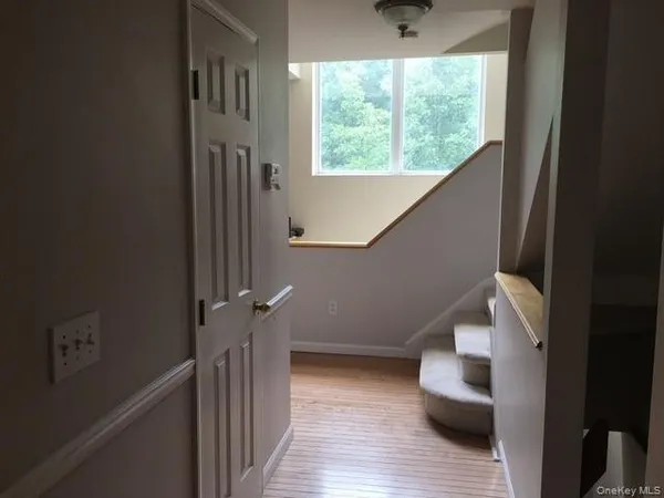 a view of entryway and hall with wooden floor