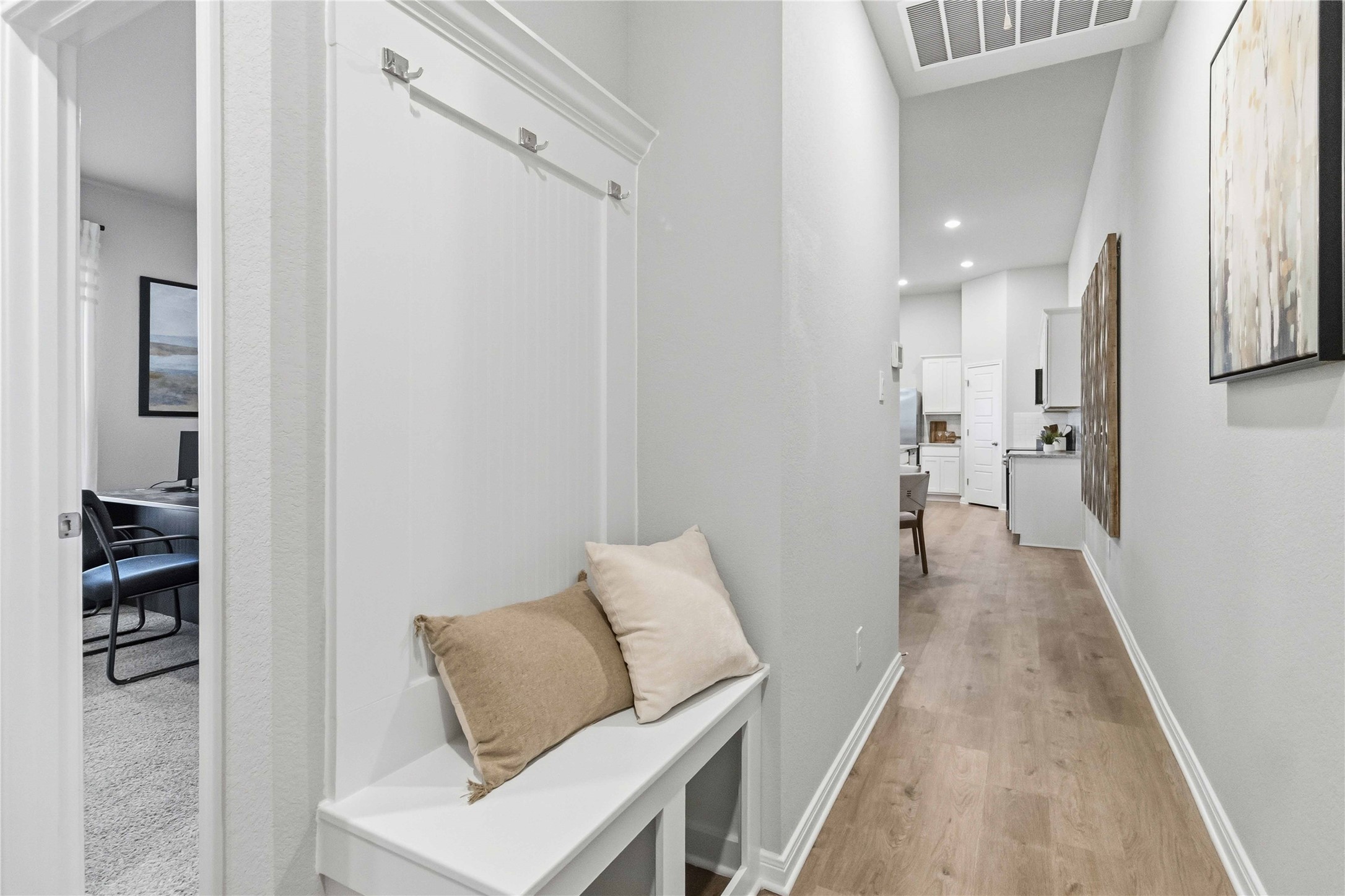 146 Gunner Road, Unit A Buda, TX 78610 - Photo 8 of 11 Smooth wood flooring and clean crown molding details accent this bright and welcoming entryway corridor.